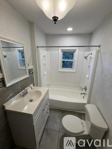 A bathroom with a toilet, sink, and bathtub.