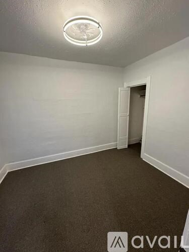 A room with a carpeted floor and a ceiling light.