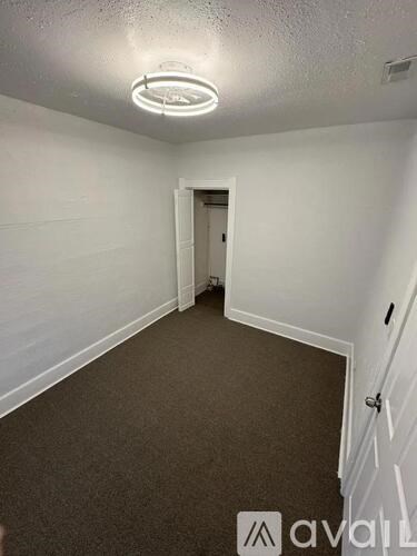A room with a carpeted floor and a doorway leading to another room.