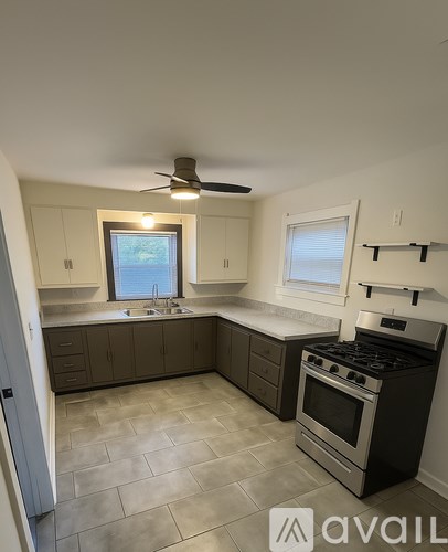 A kitchen with a black stove top oven and a fan.