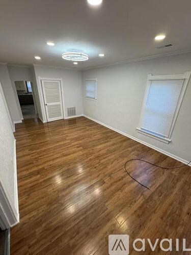 A room with wooden flooring and a white ceiling with a circular light fixture.