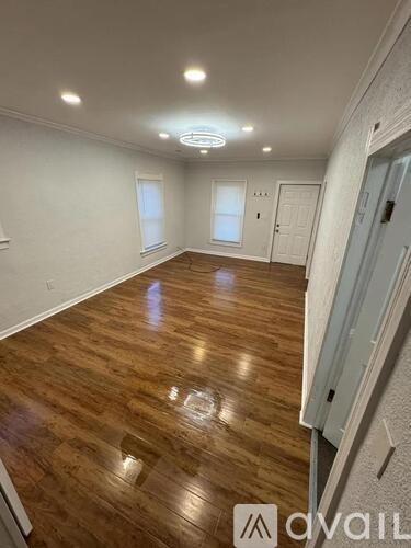 A room with wooden flooring and white walls.