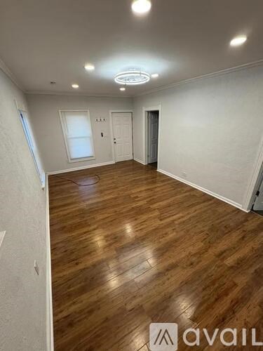 A room with wooden flooring and white walls, with a logo that reads "avaiL" on the floor.