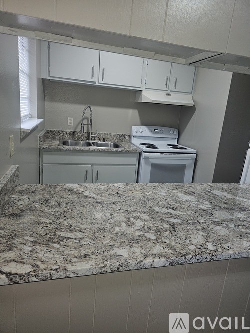 A kitchen with granite countertops and white cabinets.