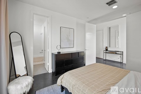 A bedroom with a large bed and a mirror on the wall.