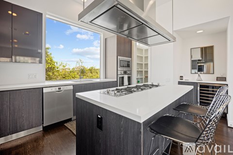 A modern kitchen with a large island and stainless steel appliances.
