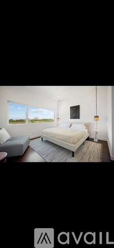 A bedroom with a large bed and a window overlooking a field.