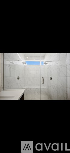 A bathroom with a white tub and a glass shower door.