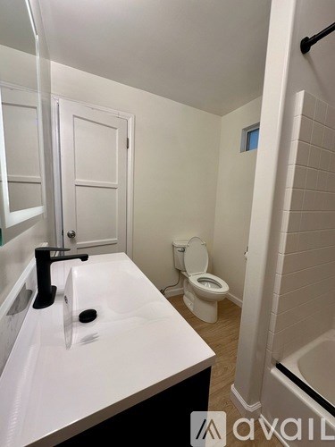 A white sink with a black faucet in a small bathroom.