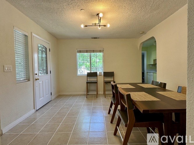 A dining room with a table and chairs.