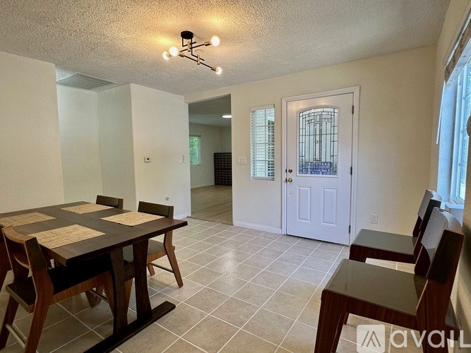 A dining room with a table and chairs.