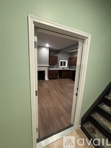 A white door opens to a kitchen.