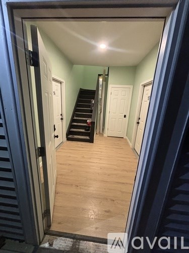 A hallway with a staircase leading to the second floor.