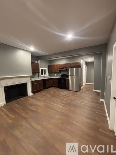 A kitchen with wooden floors and a fireplace.