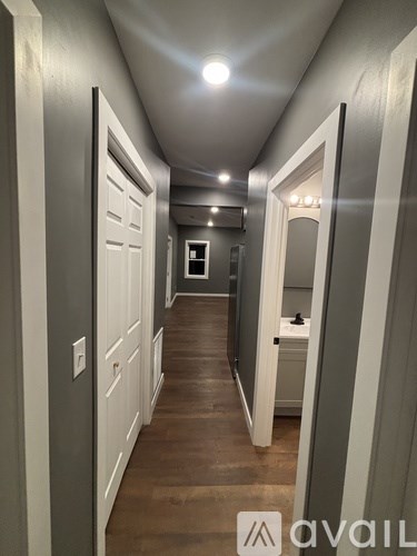 A long, narrow hallway with white doors on either side.