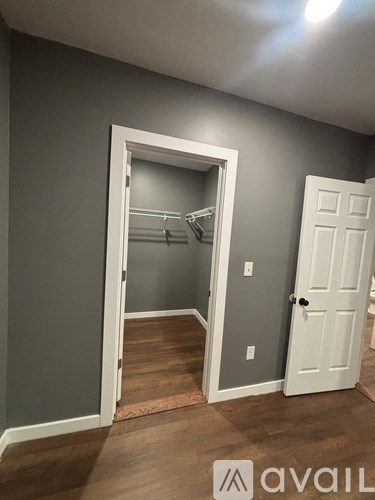 A room with a white door and a grey wall.