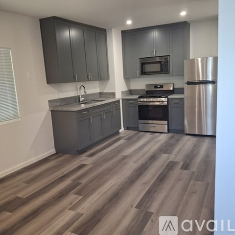 A kitchen with wooden floors and stainless steel appliances.