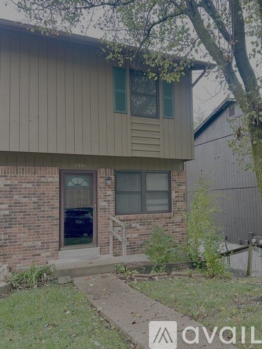 A house with a brown siding and a brick foundation.