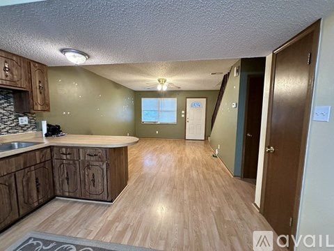 A kitchen with wooden cabinets and a countertop is available for rent.