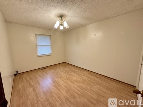 A room with wooden flooring and a window.