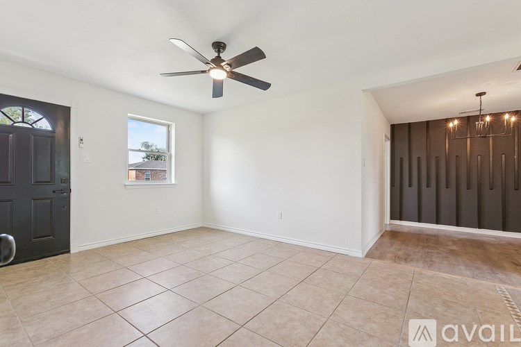 A room with a ceiling fan and tiled floor.