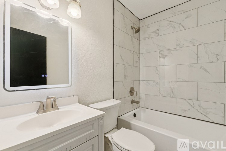 A bathroom with a white sink, toilet, and tub.