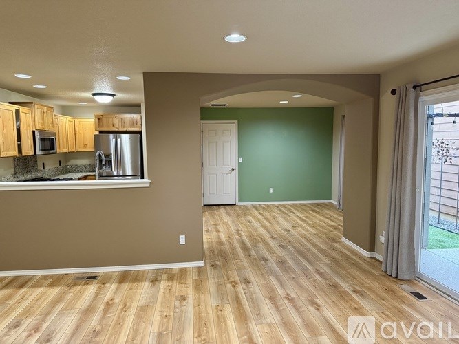 A kitchen with wooden floors and a green wall.