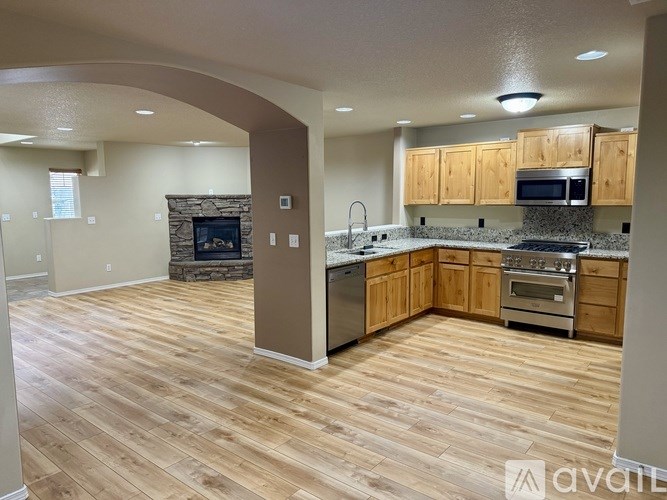 A kitchen with wooden floors and a stone fireplace.