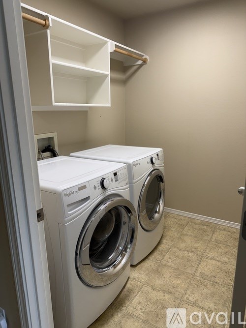 A white front load washing machine in a laundry room.