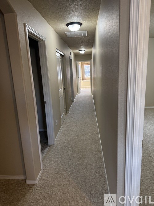 A long hallway with doors on both sides and a light on the ceiling.