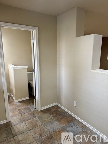 A room with a tiled floor and a white door.