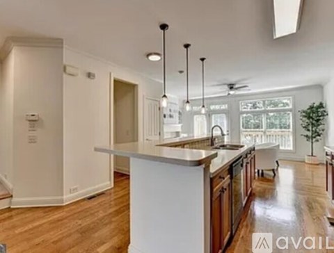 A modern kitchen with wooden floors and white walls.