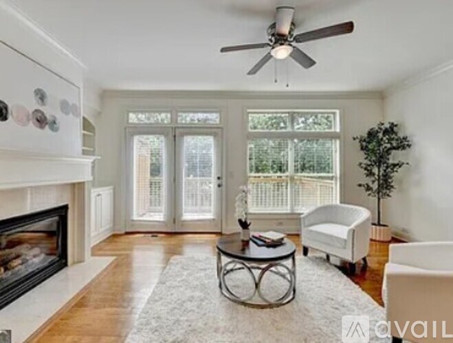 A living room with a fireplace and a ceiling fan.