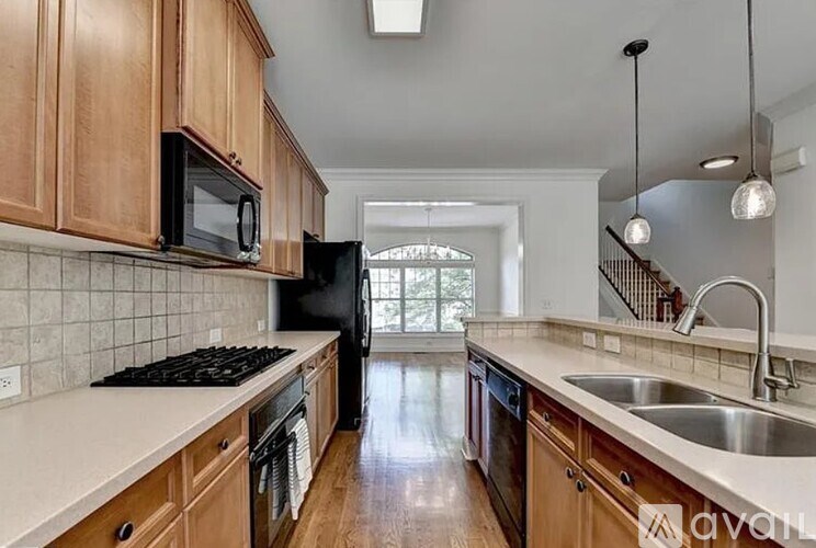A kitchen with wooden cabinets and black appliances.