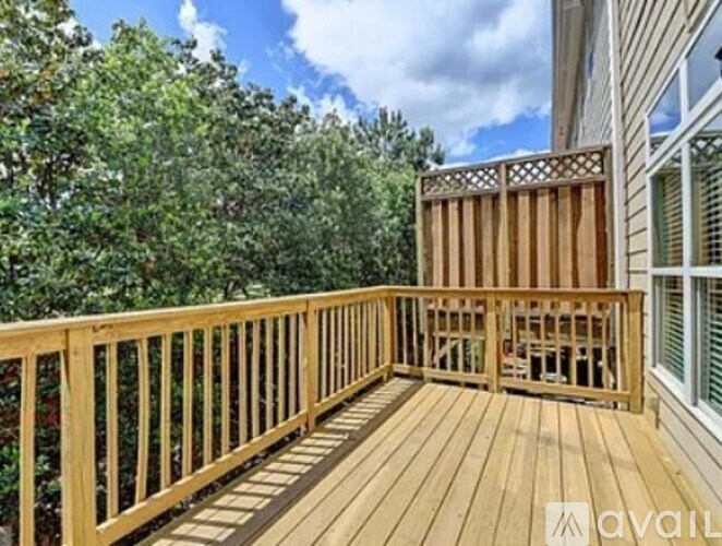 A wooden deck with a lattice fence and a small table and chairs.