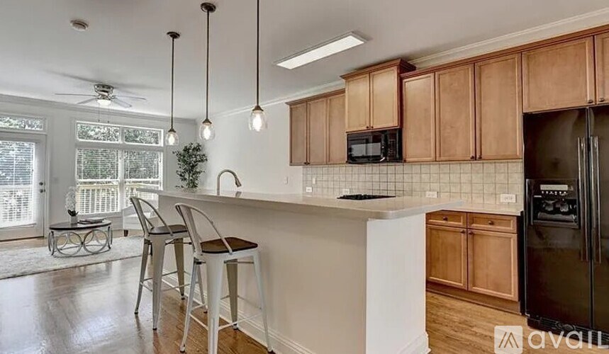 A kitchen with wooden cabinets and a black refrigerator.