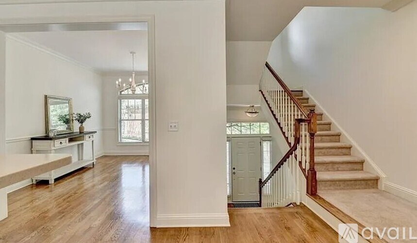 A spacious living room with a staircase leading to the upper floor.
