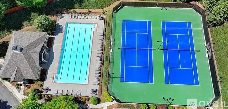 A tennis court and a swimming pool are seen from above.