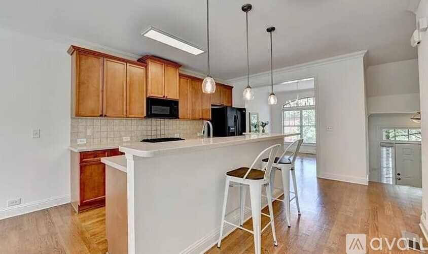 A kitchen with white countertops and wooden cabinets.