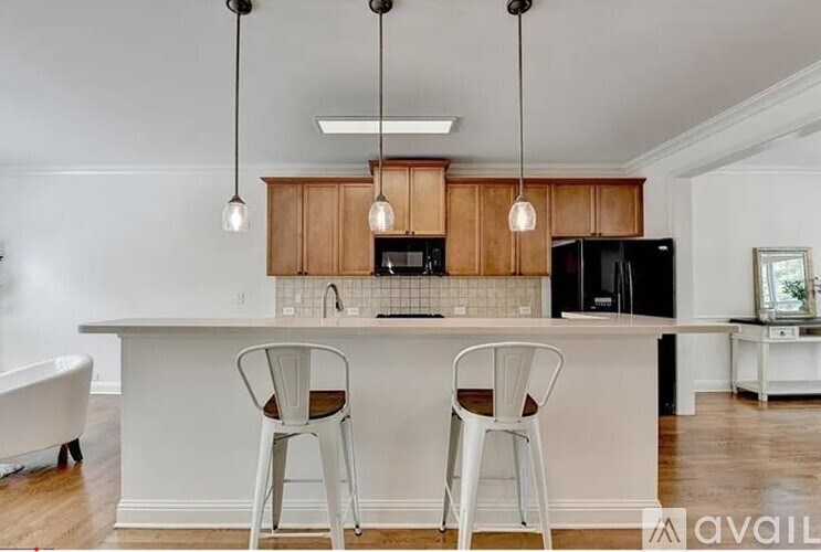 A kitchen with white chairs and a white counter.