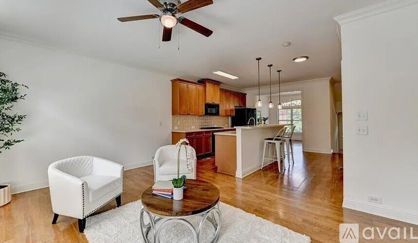 A living room with a white chair and a brown table.