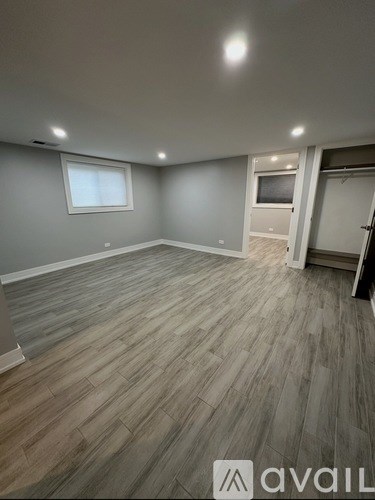 A room with wooden flooring and a window.
