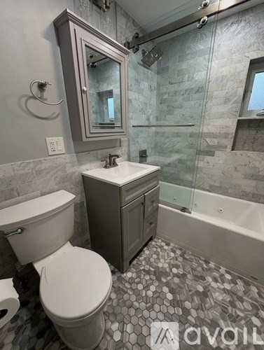 A bathroom with a toilet, sink, and a shower with a glass door.