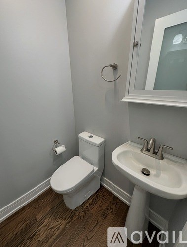 A white toilet and sink in a small bathroom.