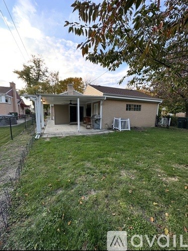 A house with a yard and a tree in front of it.