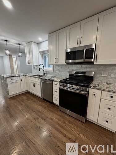 A kitchen with white cabinets and a black stove top oven.
