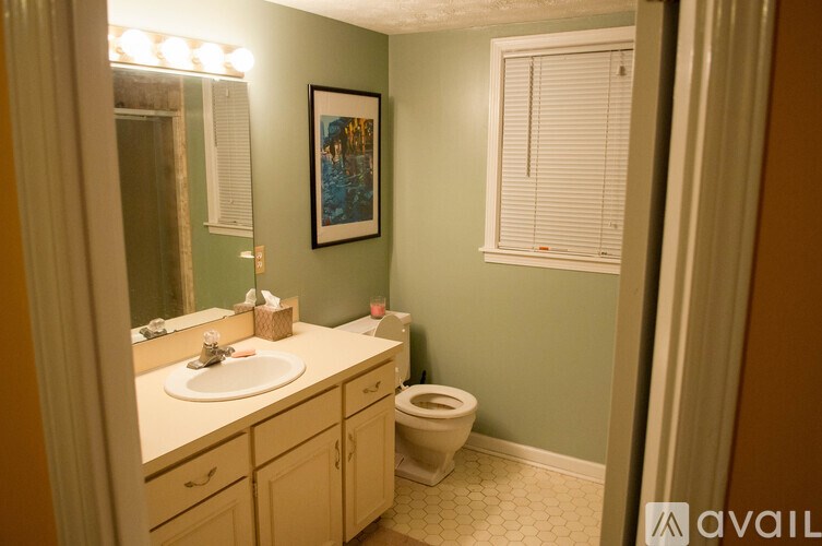 A bathroom with green walls and a white toilet.