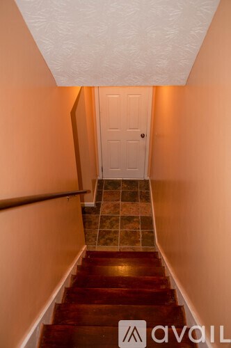 A staircase with a white door at the top.