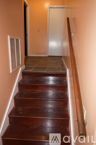 A brown wooden staircase with a white door at the top.
