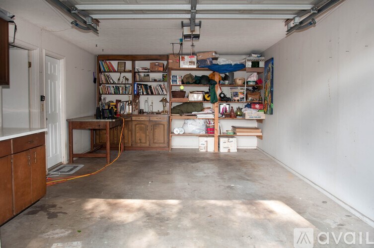 A room with a lot of items on the shelves and a white door.